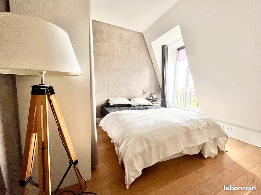 Chambre lumineuse avec lit double et lampadaire moderne.